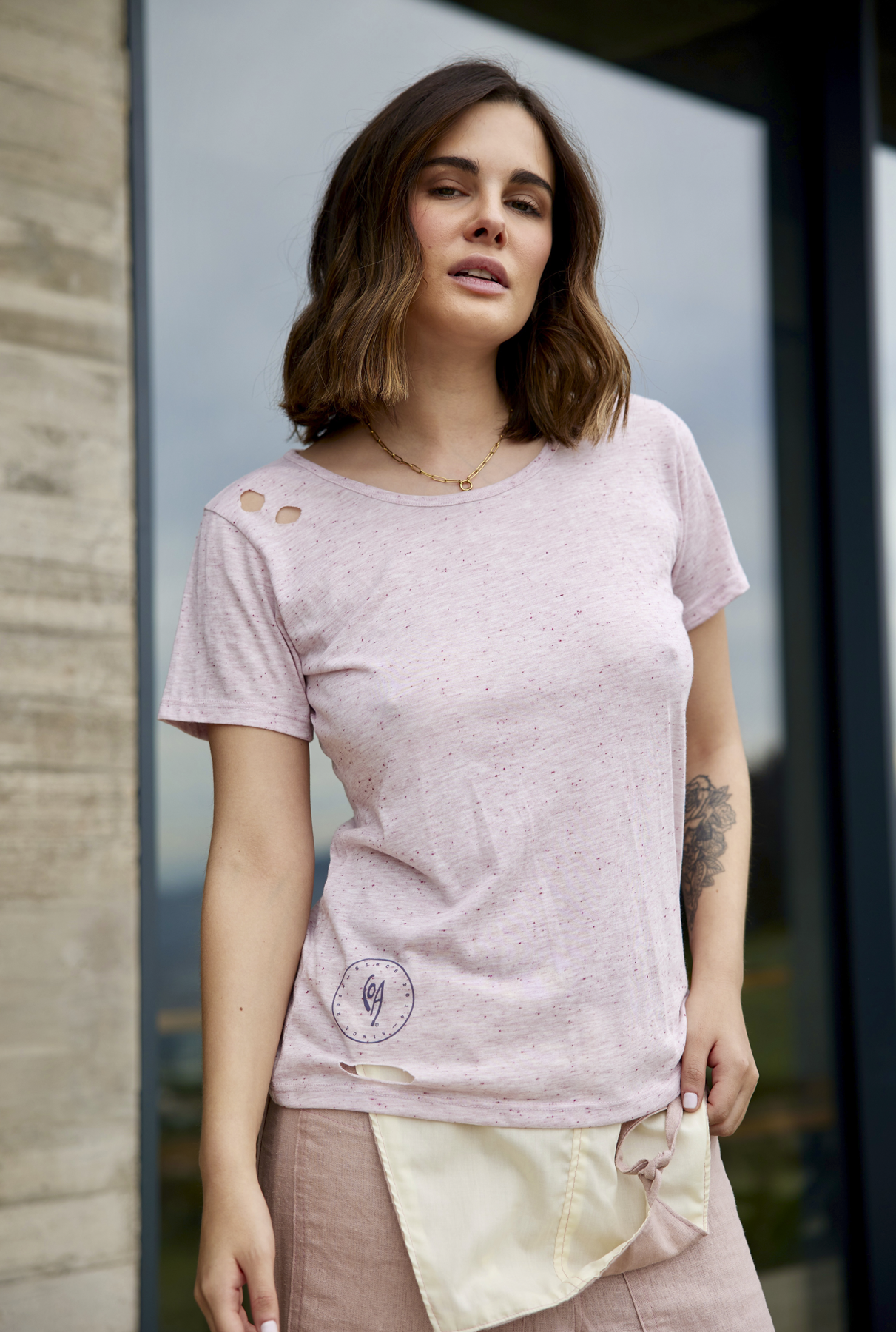 Polera CPF Malva de estilo moderno y femenino. Color malva con agujeros decorativos en los hombros y en la cintura. Logo negro estampado en el pecho. Manga corta y fit suelto.