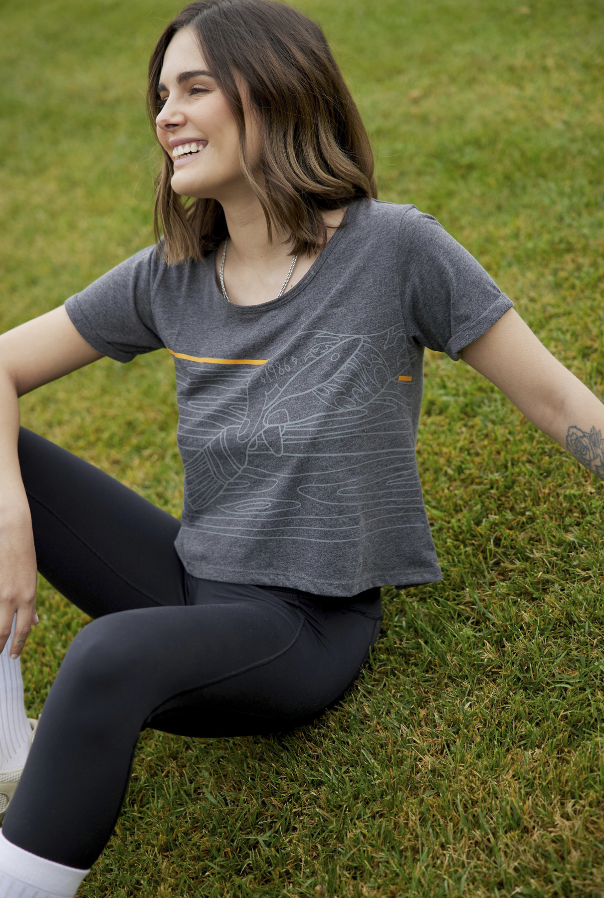 Polera de estilo artístico y moderno en cada detalle. Manga corta, estampado serigrafiado en tonos grises y detalles en naranja.