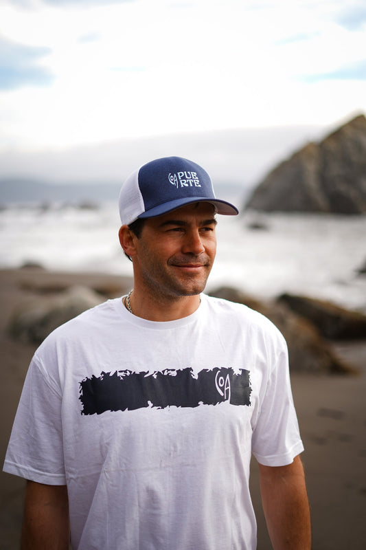 Polera Cicatriz blanca de COA puesta, vista de frente en la playa