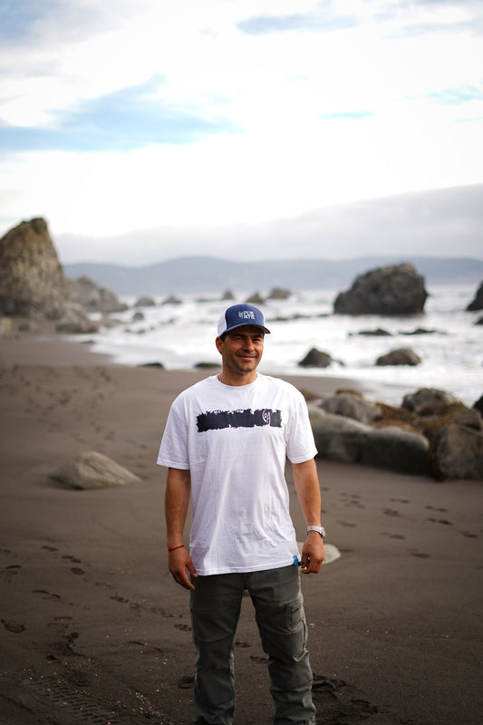Polera Cicatriz blanca de COA, cuerpo entero de frente en la costa